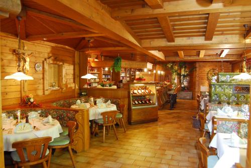 a restaurant with tables and chairs in a room at Das Grünholz Aparthotel in Mühlbach am Hochkönig