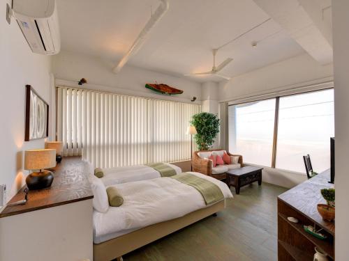 a living room with a large bed and a couch at Sound Swell Resort in Minamiboso