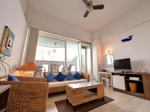 a living room with a couch and a tv at Sound Swell Resort in Minamiboso