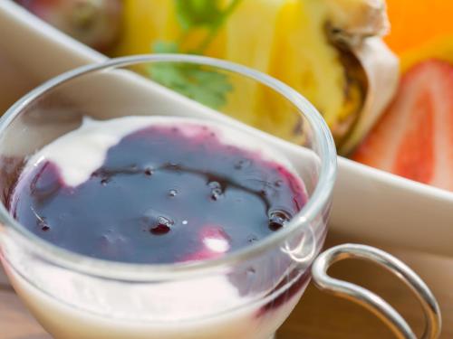 una tazza di vetro con del liquido dentro accanto a un piatto di cibo di Sound Swell Resort a Minamiboso