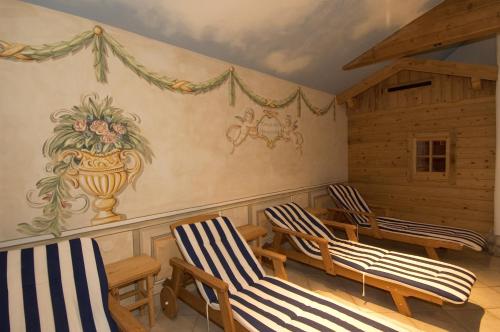 a room with two chairs and a painting on the wall at Das Grünholz Aparthotel in Mühlbach am Hochkönig