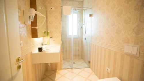 a bathroom with a shower and a sink at Royal Hill Hotel in Tirana
