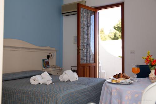 a bedroom with two beds and a table with a plate of food at Camping Village La Pineta in San Vito lo Capo