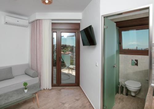 a bathroom with a toilet and a sliding glass door at DIKAP Luxury Aparts in Limenaria