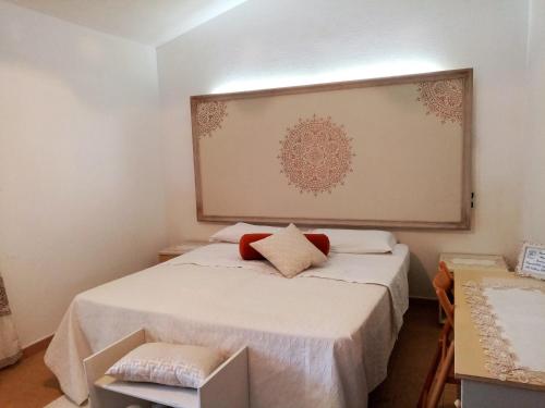 a small room with a bed with a large picture on the wall at Su Pranu in Onifai