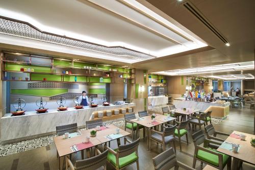 a restaurant with tables and chairs and a chef at Amari Pattaya in Pattaya Central