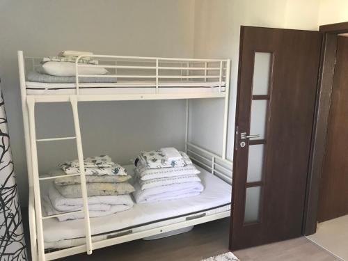 Pokój z łóżkiem piętrowym i białymi ręcznikami w obiekcie Jantar w mieście Jantar