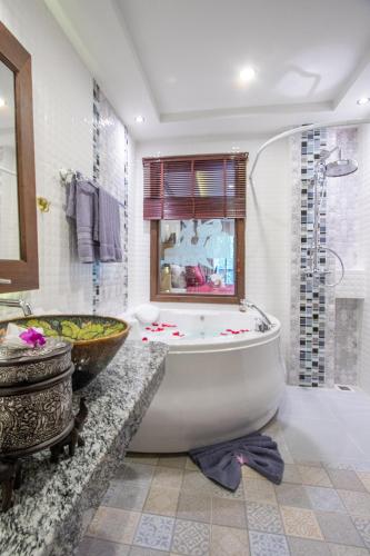 a bathroom with a large tub and a sink at Thanyawintra Boutique and Spa in Chiang Mai