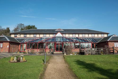 a large brick building with a green lawn in front of it at De Vere Latimer Estate in Chesham