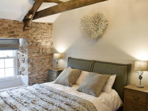a bedroom with a bed and a stone wall at no 8 main street in Sedbergh