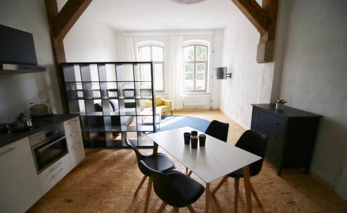a kitchen with a table and chairs in a room at Nr9Marinehafen - Ferienwohnungen in Stralsund