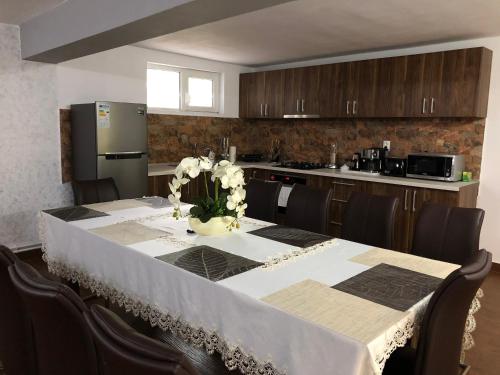 a kitchen with a table with a vase of flowers on it at Casa Antonia in Chişcău