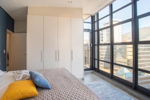 a bedroom with a bed and a large window at City Penthouse Kapstadt in Cape Town