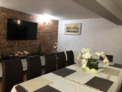 a dining room with a table and chairs and a television at Casa Antonia in Chişcău