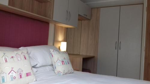 a bedroom with a bed with white sheets and pillows at Porth Retreat at Newquay Bay Resort in Newquay