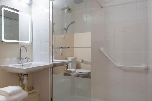a bathroom with a sink and a shower and a toilet at Comfort Hotel Aeroport Lyon St Exupery in Saint-Exupéry