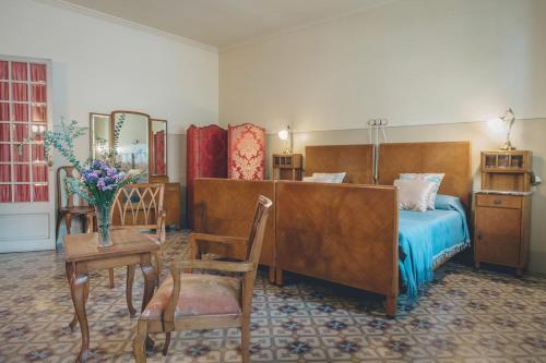 a bedroom with a bed and a table and chairs at Casa Baulenas in Caldes d'Estrac