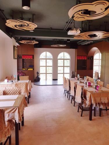 une salle à manger avec tables, chaises et fenêtres dans l'établissement Moon Shine B&B, à Touwu