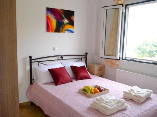 a bedroom with a bed with a tray of fruit on it at Marathona's Apartment in Aegina Town