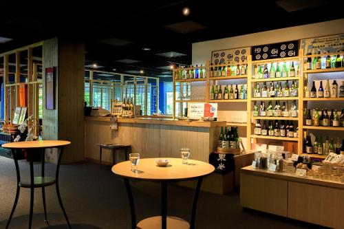 a bar with two tables and bottles of wine at Meitoya So in Zao Onsen