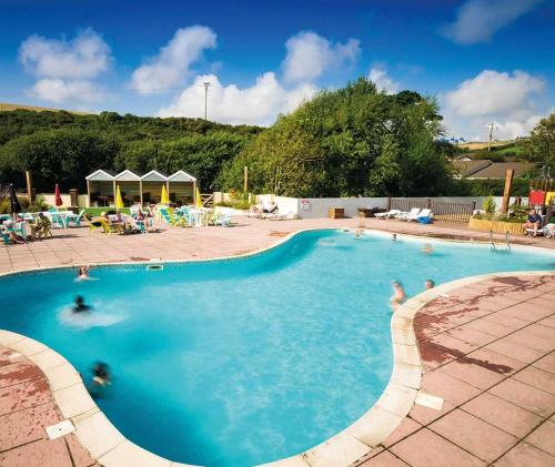 a large swimming pool with people in the water at Porth Retreat at Newquay Bay Resort in Newquay