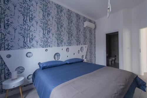 um quarto com uma cama azul e um papel de parede azul e branco em B&B Napoli Centro em Nápoles