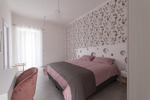 1 dormitorio con 1 cama y una pared con flores en B&B Napoli Centro, en Nápoles