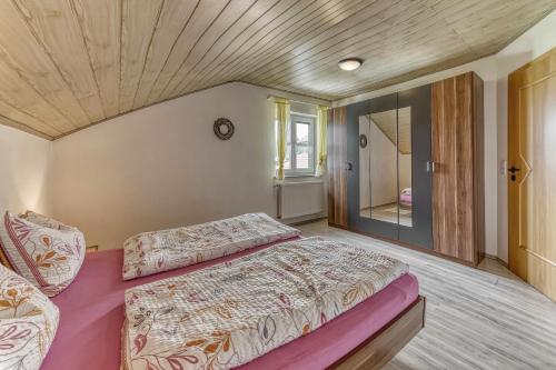 ein Schlafzimmer mit einem großen Bett und einer Holzdecke in der Unterkunft Ferienwohnung Barth in Tittling