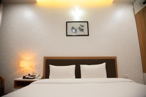 a bedroom with a large bed with two pillows at Bình Minh Hotel in Ha Tinh