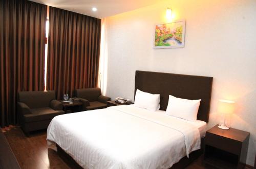 a hotel room with a bed and a chair at Bình Minh Hotel in Ha Tinh