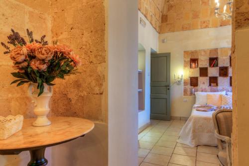 a vase of flowers on a table in a room at Masseria Sorani in Manduria
