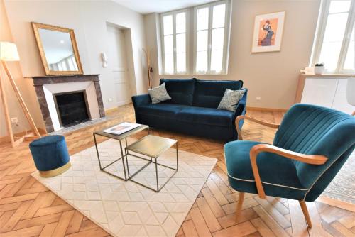 a living room with a blue couch and chairs at Le 57 by Sparnapart in Épernay