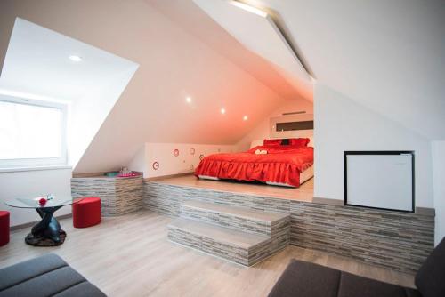 1 dormitorio con cama roja en el ático en Guesthouse Prenočišča Širec, en Ptuj