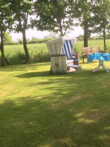 a couple of chairs and a table in the grass at Ferienwohnanlage Sturmhöhe in Welt