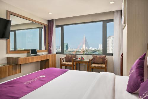 ダナンにあるLavender Riverside Hotelのベッド付きのホテルルームで、市街の景色を望めます。