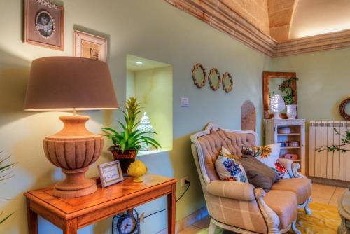a living room with a chair and a lamp on a table at Masseria Sorani in Manduria
