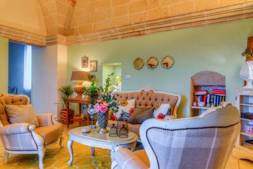 a living room with a couch and chairs and a table at Masseria Sorani in Manduria