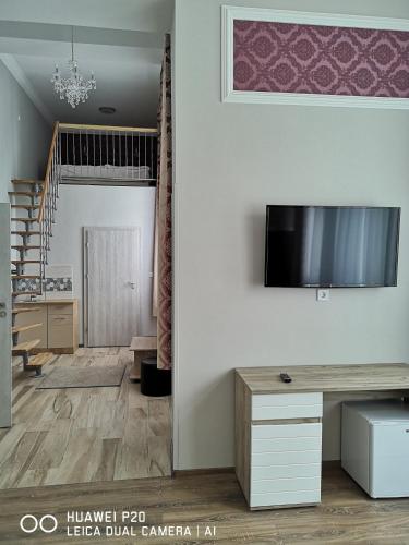 a living room with a flat screen tv on a wall at Kakukk Panzió in Nyírbátor