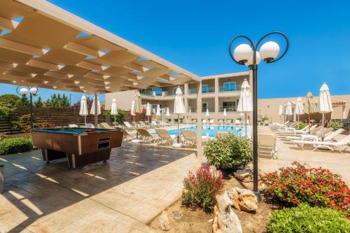 a pool area with a pool table and a resort at Vice Hotel in Laganas