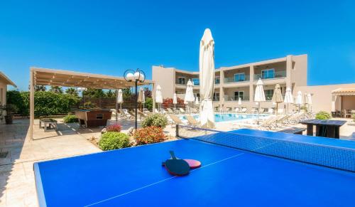 a blue ping pong table in front of a pool at Vice Hotel in Laganas