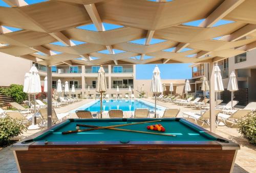 a pool table in front of a swimming pool at Vice Hotel in Laganas