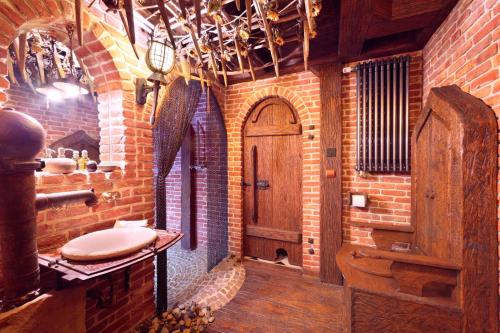 a brick bathroom with a sink and a wooden door at Attic Apartment Warszawa in Warsaw