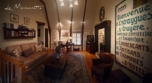 a living room with a couch and a table at La Maisonnette in Entraygues-sur-Truyère