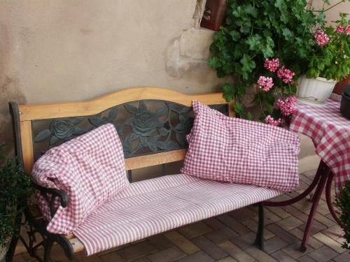 a wooden chair with two pillows on a patio at Gite Dans Cité Médievale in Boersch