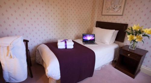 a hotel room with a bed with a laptop on it at The Jacobean Hotel in Coventry