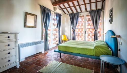 a bedroom with a green bed and a window at Appartamento con vista panoramica e piscina in Capannori