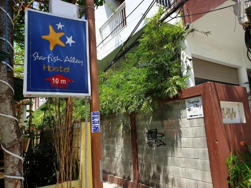 a sign for a hotel in front of a building at Starfish Alley Hostel in Da Nang