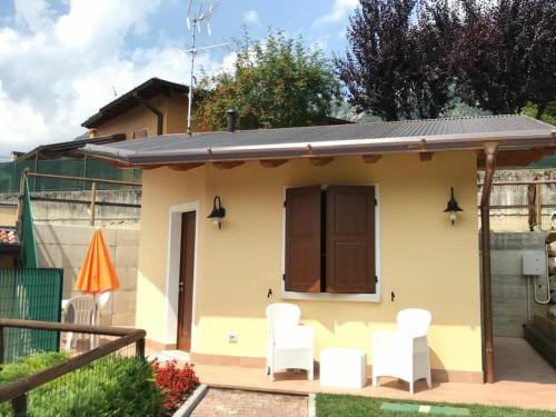 a small house with white chairs in a yard at B&B Isola Verde in Villa