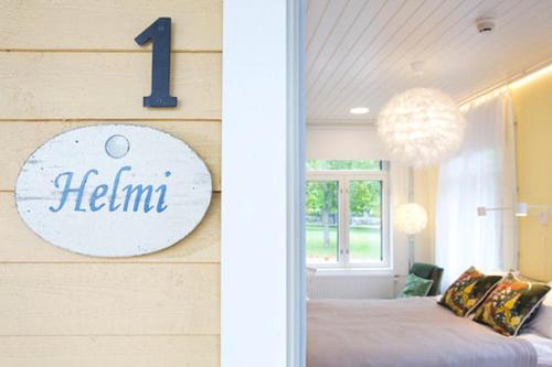 a bedroom with a bed and a sign on a wall at Hotel Amandis in Naantali