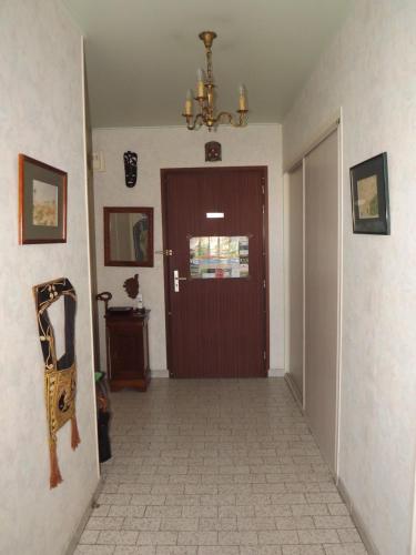 a hallway with a brown door and a tile floor at L'Arinella in Bastia